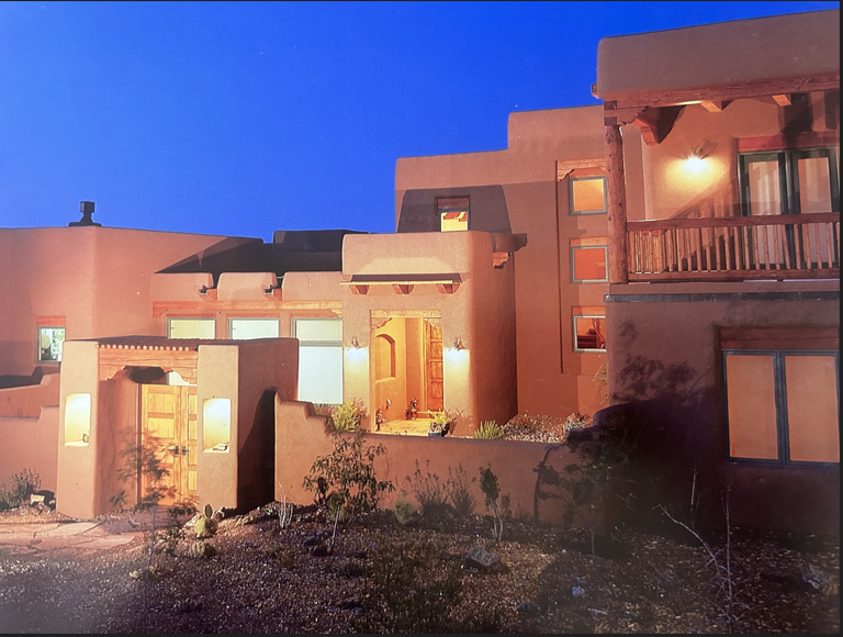 Custom New Mexico home exterior with warm lighting at dusk