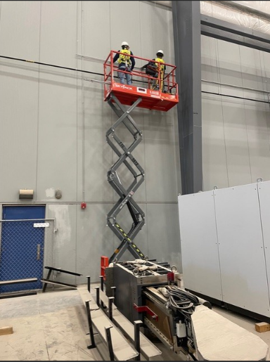McFall Electric crew working on scissor lift inside commercial building